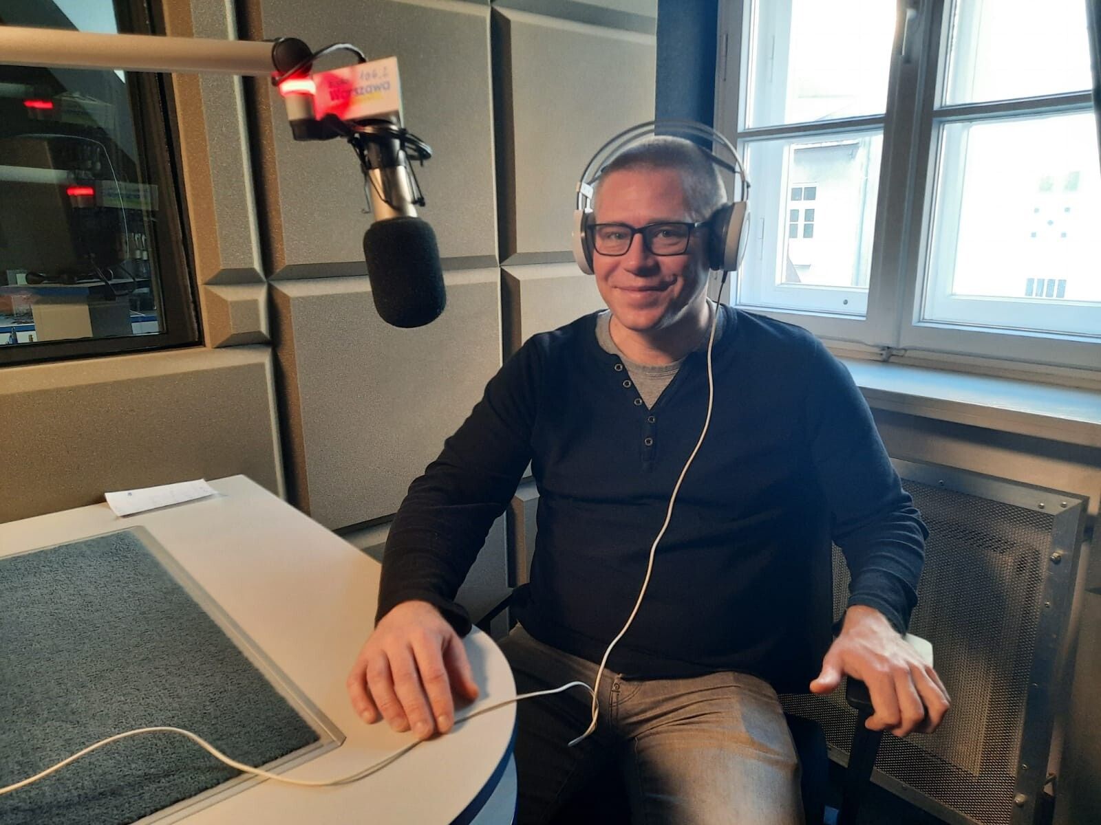 Piotr Jurkowski przy mikrofonie podczas nagrania audycji Boskie CV w Radiu Warszawa.